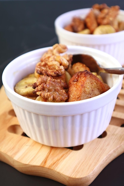 Budino di pane alle noci di banana al forno fresco in una ciotola bianca