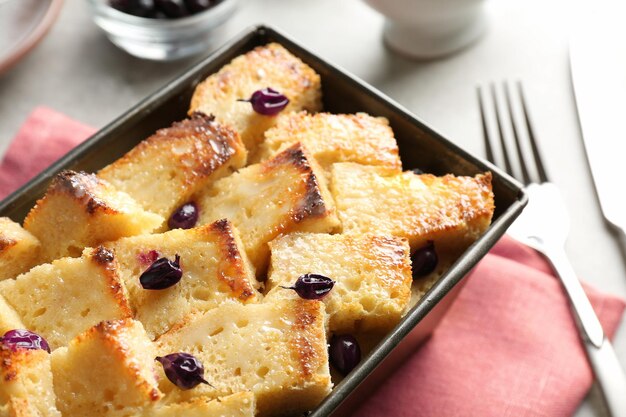 Budino di pane delizioso con ribes in teglia sul tavolo da cucina