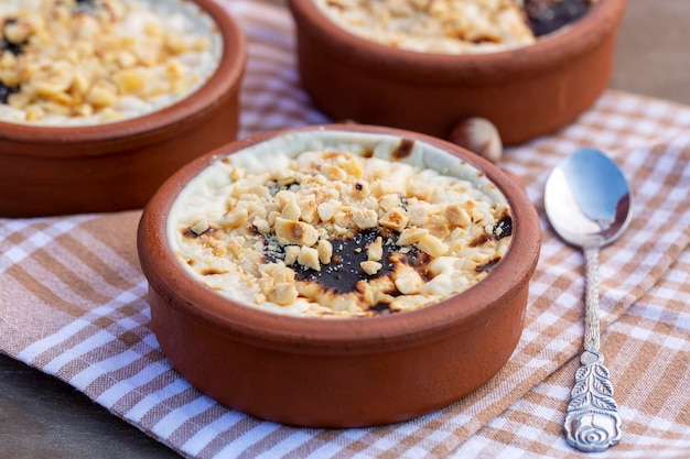 Budino di riso al forno sutlac dolce al latte turco in casseruola di terracotta con nocciole