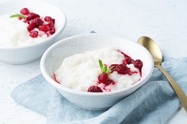 Budino di riso, vista laterale. Prima colazione sana di dieta del vegano con latte di cocco, lampone, scandinavo