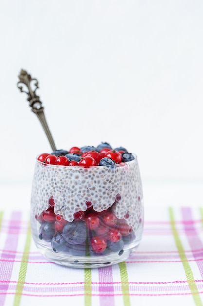 Budino di semi di Chia con mirtilli e bacche di ribes in un bicchiere