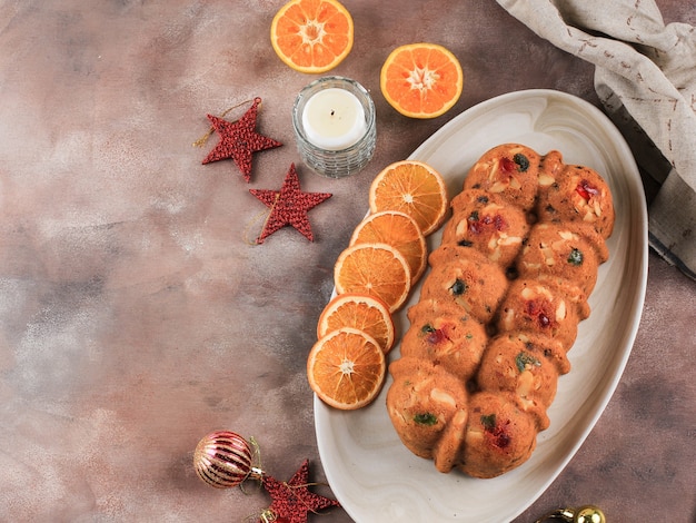 Budino di torta di frutta secca di Natale al rum fatto in casa per la festa di famiglia. Servito su un tavolo di cemento marrone con Sunkist essiccato