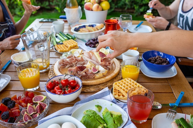 Buffet La famiglia fa colazione in terrazza Una famiglia numerosa mangia a tavola