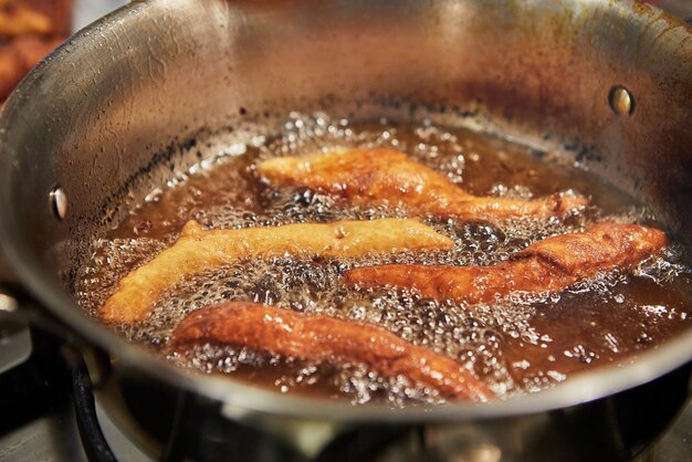 Bugnes ciambelle francesi in olio bollente in casseruola