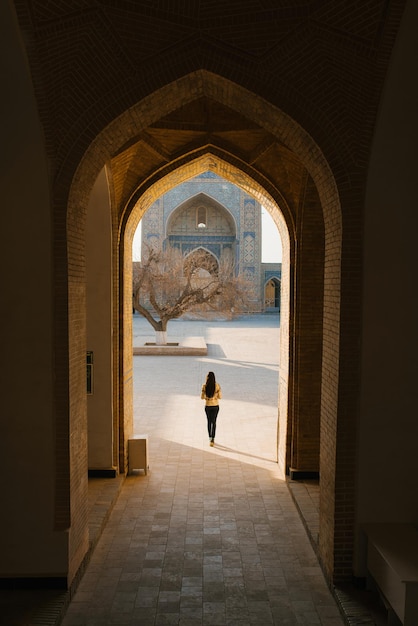 Bukhara Uzbekistan marzo 2022 La ragazza sta con le spalle alla porta del minareto Kalyan