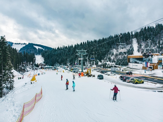 BUKOVEL, UCRAINA - 9 dicembre 2018 - persone che sciano e fanno snowboard giù per la collina. attività invernale. concetto di viaggio