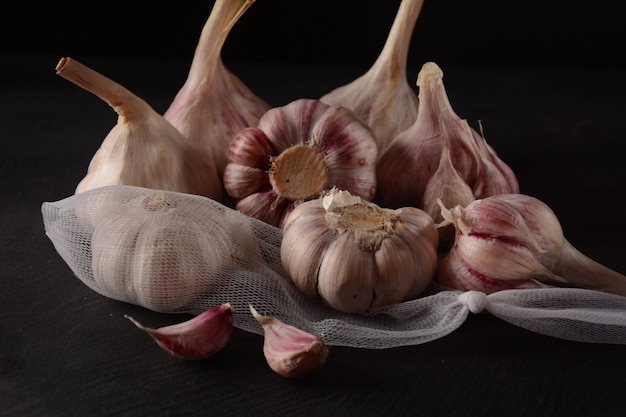 Bulbi di aglio viola fresco su sfondo nero