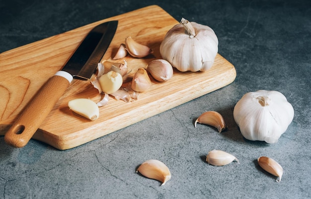 Bulbo d'aglio su macellaio di legno e coltello in cucinaIngredientspicesalimenti sani