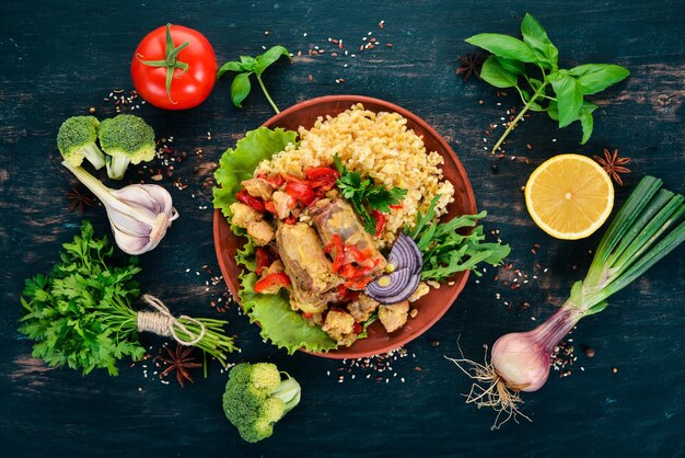 Bulgur con carne paprika pomodorini e verdure su uno sfondo di legno Vista dall'alto Copia spazio