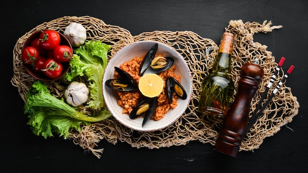 Bulgur con cozze e salsa di pomodoro in un piatto Sullo sfondo vecchio Vista dall'alto Spazio libero per il testo