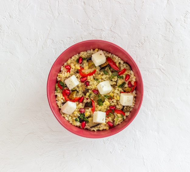 Bulgur con formaggio, pepe, melanzane e melograno.