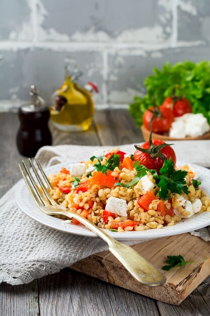 Bulgur con peperoni arrostiti, pomodori, prezzemolo e formaggio feta