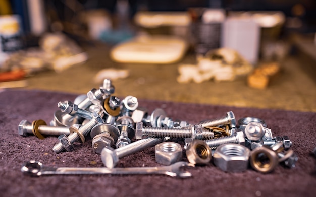 Bulloni metallici e una chiave inglese giacciono sul tavolo di lavoro dell'assemblatore