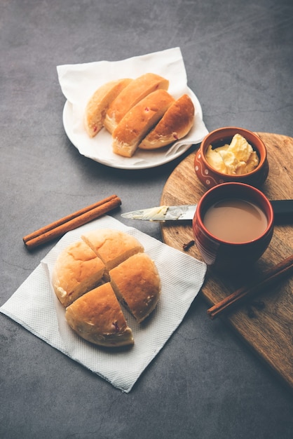 Bun-maska Tea o bun Maska chai combo presenta un panino leggermente dolce tempestato di uvetta che viene tagliato a metà e carico di burro sano, cibo di Mumbai