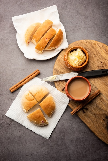 Bun-maska Tea o bun Maska chai combo presenta un panino leggermente dolce tempestato di uvetta che viene tagliato a metà e carico di burro sano, cibo di Mumbai