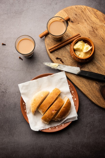 Bun-maska Tea o bun Maska chai combo presenta un panino leggermente dolce tempestato di uvetta che viene tagliato a metà e carico di burro sano, cibo di Mumbai