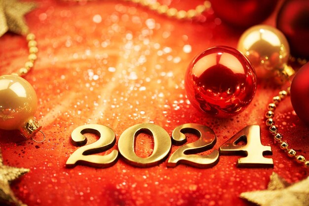 Buon anno 2024 Numeri d'oro su sfondo rosso con decorazioni natalizie