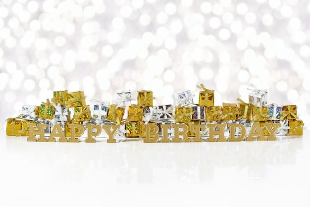 Buon compleanno testo dorato sullo sfondo di regali d'oro e d'argento su uno sfondo bokeh