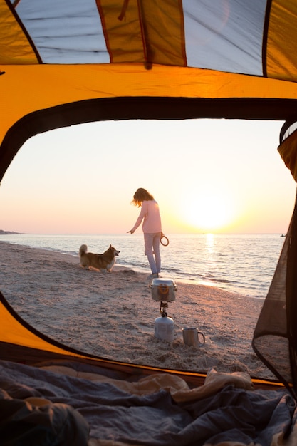 Buon fine settimana divertente al mare - ragazza che gioca con un cane sulla spiaggia. Estate