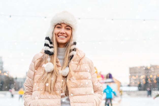 Buon inverno nella strada in piedi della ragazza affascinante della grande città