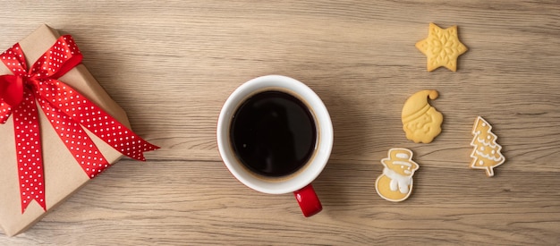 Buon Natale con biscotti fatti in casa e tazza di caffè su sfondo tavolo in legno Festa della vigilia di Natale e concetto di felice anno nuovo