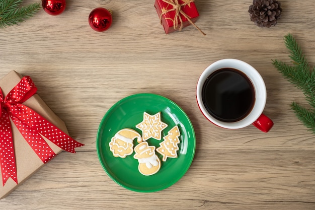 Buon Natale con biscotti fatti in casa e tazza di caffè sul fondo della tavola in legno. Vigilia di Natale, festa, vacanza e concetto di felice anno nuovo