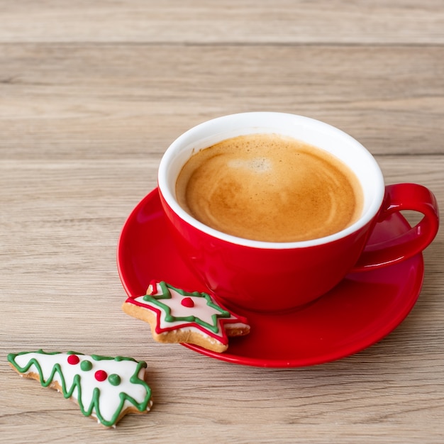 Buon Natale con biscotti fatti in casa e tazza di caffè sul fondo della tavola in legno. Vigilia di Natale, festa, vacanza e concetto di felice anno nuovo