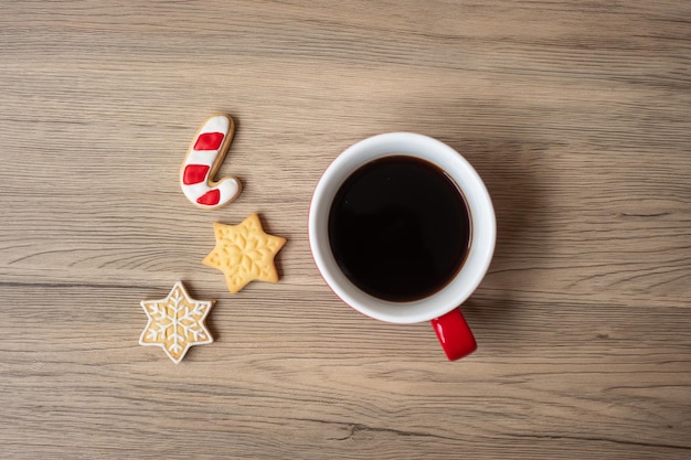 Buon Natale con biscotti fatti in casa e tazza di caffè sul fondo della tavola in legno. Vigilia di Natale, festa, vacanza e concetto di felice anno nuovo