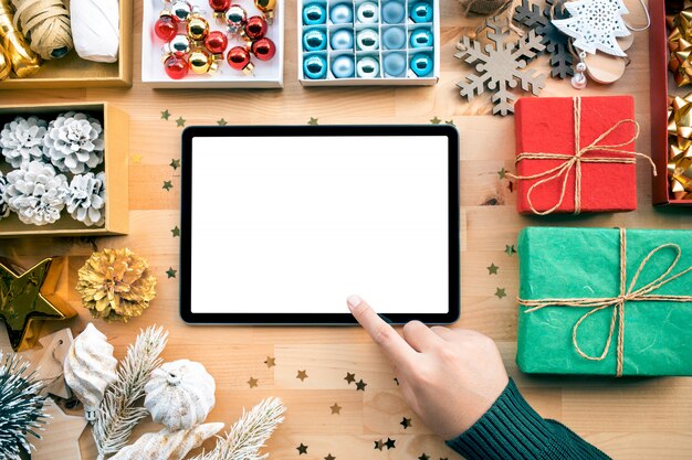 Buon Natale con la giovane femmina utilizzando tablet e ornamento