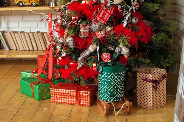 Buon Natale e Anno Nuovo. Classico albero verde decorato con regali sotto