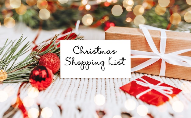 Buon natale e buon anno nuovo concetto con scatole regalo e biglietto di auguri con testo Christmas Shopping List Christmas