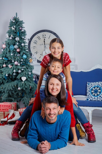 Buon Natale e Buone Feste. Bella famiglia di quattro persone che si divertono all'interno di Natale.