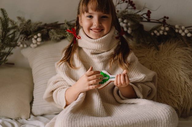 Buon Natale e Buone Feste. Il bambino gioca con i biscotti di pan di zenzero. Aspettando Natale.