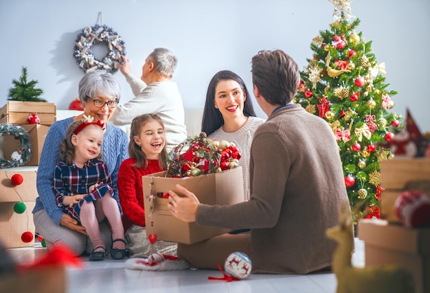 Buon Natale e buone feste Nonni madre padre bambini decorano l'albero in camera