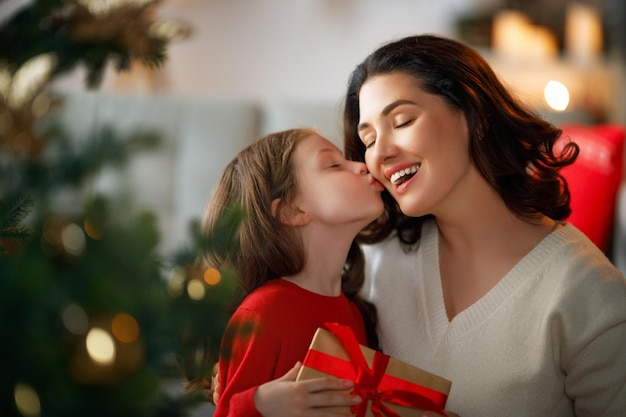 Buon Natale e buone vacanze una mamma allegra e la sua adorabile figlia si scambiano regali