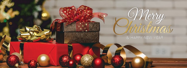 Buon Natale e felice anno nuovo banner per la testa o la copertina del sito web dei social media o della fan page decorativa. Foto di ornamenti decorativi con testo di benedizione natalizia e lettere con scatole regalo e palla.