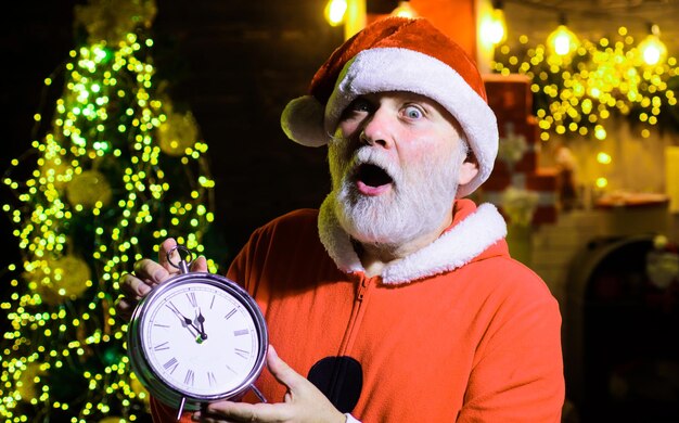 Buon natale e felice anno nuovo hanno sorpreso babbo natale con il vecchio orologio per festeggiare