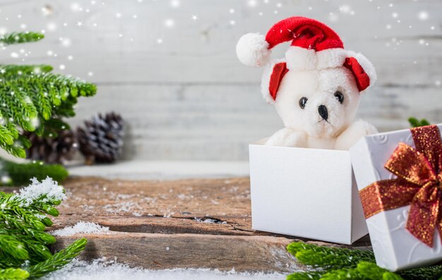 Buon Natale e Felice Anno Nuovo, stagione invernale con neve e decorazioni. Orsacchiotto con confezione regalo.