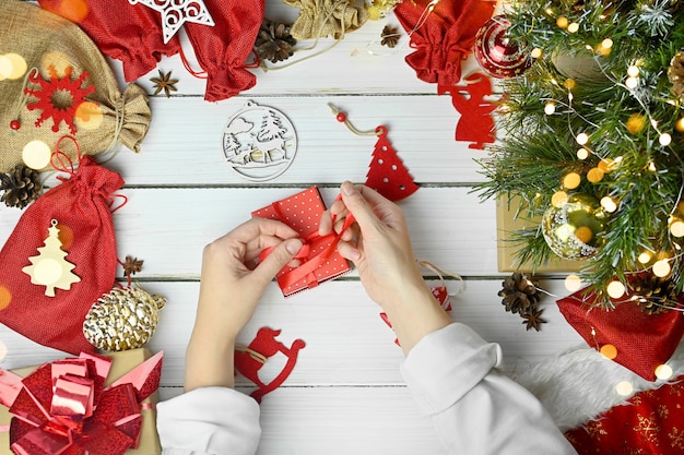 Buon Natale e Felice Anno nuovo. Una donna tiene una confezione regalo accanto ad altre sorprese in sacchetti per l'Avvento per bambini.