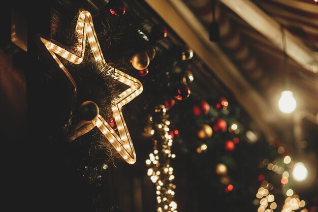 Buon Natale Elegante illuminazione a stella di Natale e luci festive sui rami di abete la sera all'aperto Decorazioni natalizie moderne in una strada cittadina Atmosferiche vacanze invernali in Europa