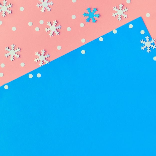 Buon Natale! La carta creativa piatta giaceva in rosa, blu e bianco con fiocchi di neve