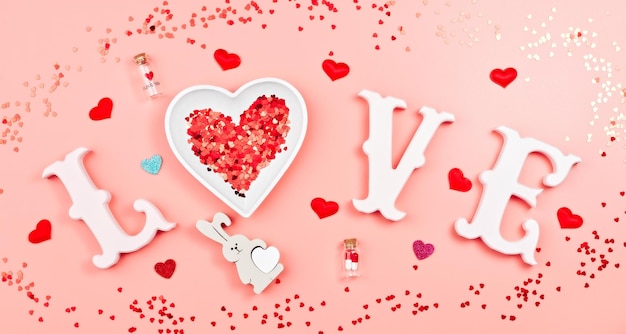 Buon San Valentino, festa della mamma, 8 marzo, concetto di biglietto di auguri per la Giornata mondiale della donna. Disposizione piatta. parola amore in lettere bianche su uno sfondo rosa alla moda.