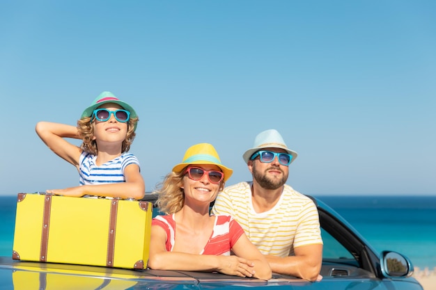 Buon viaggio in famiglia in auto al mare Madre, padre e figlia, divertirsi in cabriolet blu Concetto di vacanza estiva