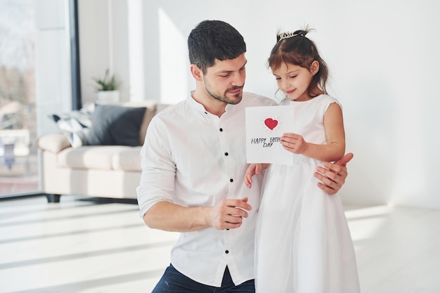 Buona festa del papà La figlia fa una sorpresa per il papà regalando una cartolina con il cuore