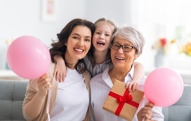 Buona festa della donna Bambino mamma e nonna con palloncini d'aria Nonna mamma e ragazza sorridenti