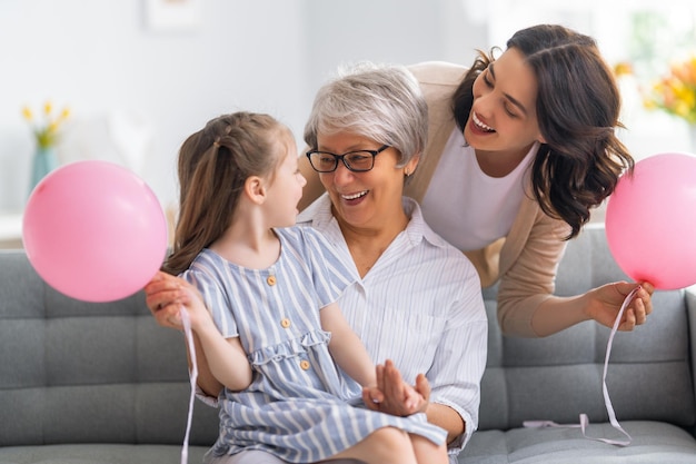 Buona festa della donna Bambino mamma e nonna con palloncini d'aria Nonna mamma e ragazza sorridenti