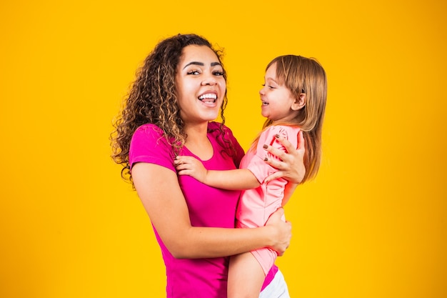 Buona festa della mamma! Adorabile bambino caucasico con sua madre su sfondo giallo.