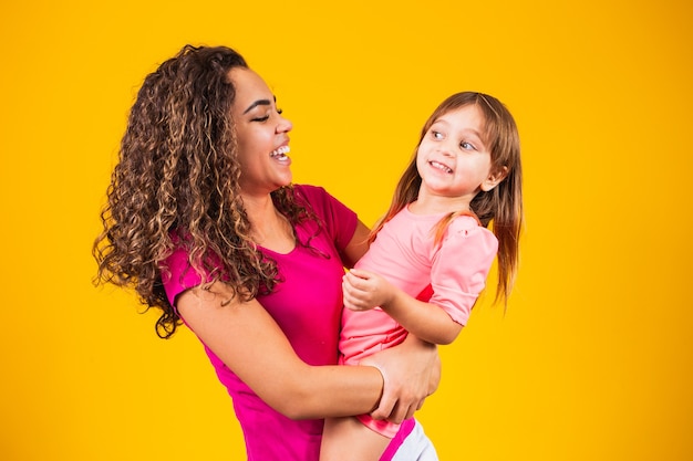 Buona festa della mamma! Adorabile bambino caucasico con sua madre su sfondo giallo.