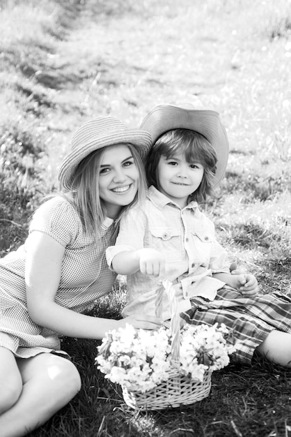 Buona festa della mamma con figlio al picnic Mamma di famiglia con bambino seduto sull'erba nel parco