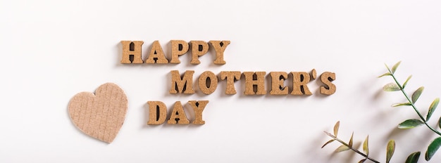 Buona festa della mamma Lettere di legno cuori di cartone e rami di eucalipto Banner web